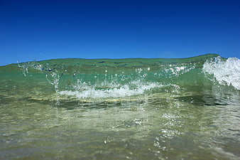 Crystal Clear Ocean Wave Breaking on Sandy Beach
