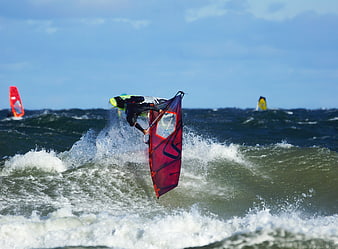 Windsurfer performing aerial jump on ocean waves