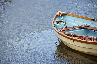 Small wooden boat with blue interior on calm water