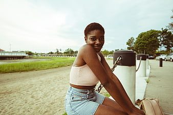 Young Black Woman Sitting Outdoors by the Water