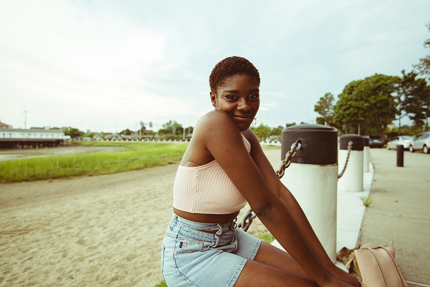 Young Black Woman Sitting Outdoors by the Water