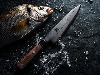 Fresh Whole Fish and Damascus Chef Knife on Dark Slate