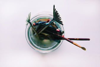 Top View of Paint Brushes in Glass Jar with Water