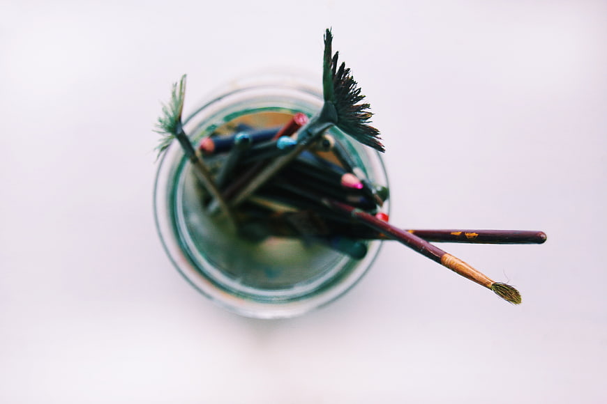 Top View of Paint Brushes in Glass Jar with Water
