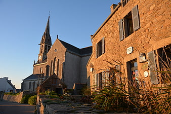 Sunlit stone church and buildings in Brittany village