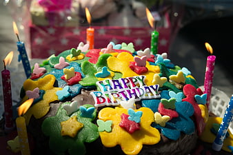Colorful Birthday Cake with Lit Candles and Decorations
