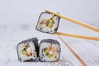 Korean Gimbap Rolls with Chopsticks on White Wooden Table
