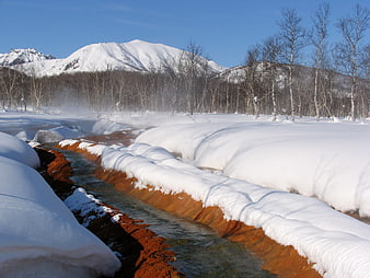 Steaming Hot Spring Stream in Snowy Kamchatka Landscape
