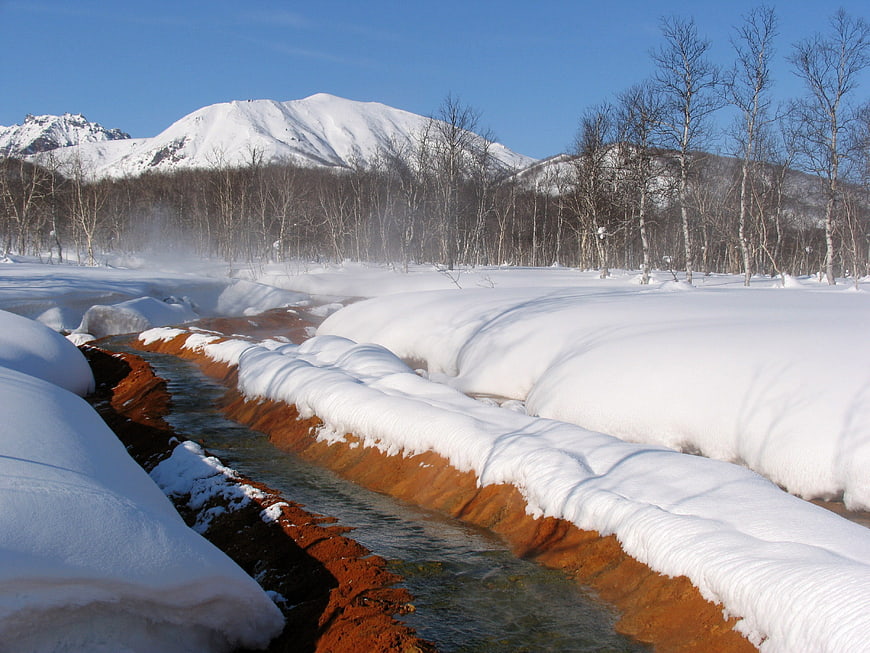 Steaming Hot Spring Stream in Snowy Kamchatka Landscape