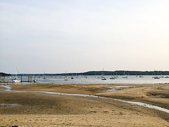 Sandy Beach at Low Tide with Moored Sailboats