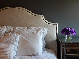 Elegant Bedroom Interior with Beige Headboard and Purple Flowers