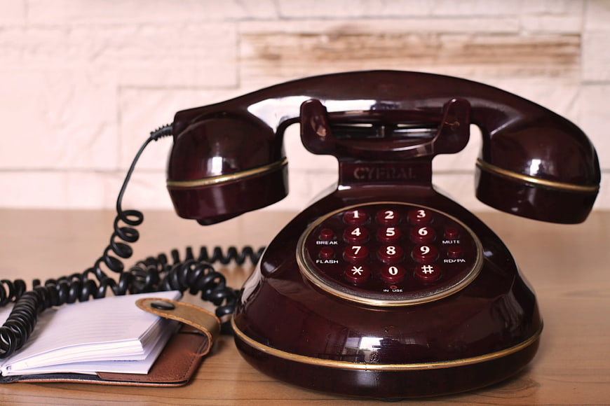 Vintage Maroon Retro Telephone on Wooden Desk