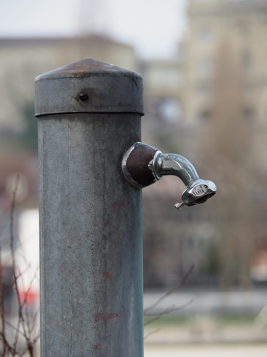 Close-up of a rusty outdoor water tap on a metal post