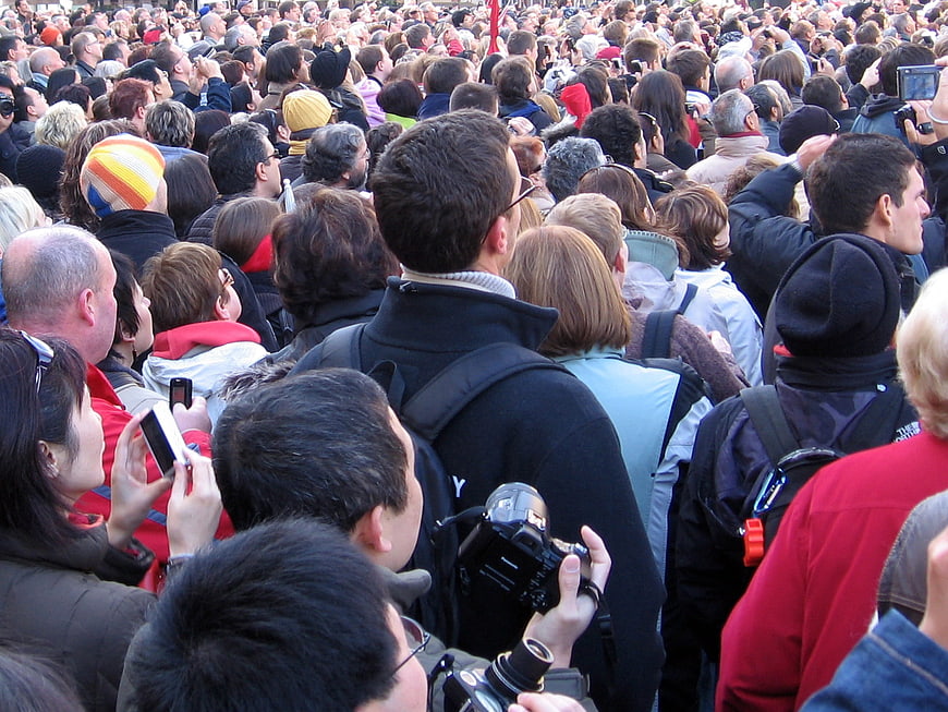 Large crowd of spectators watching event from behind
