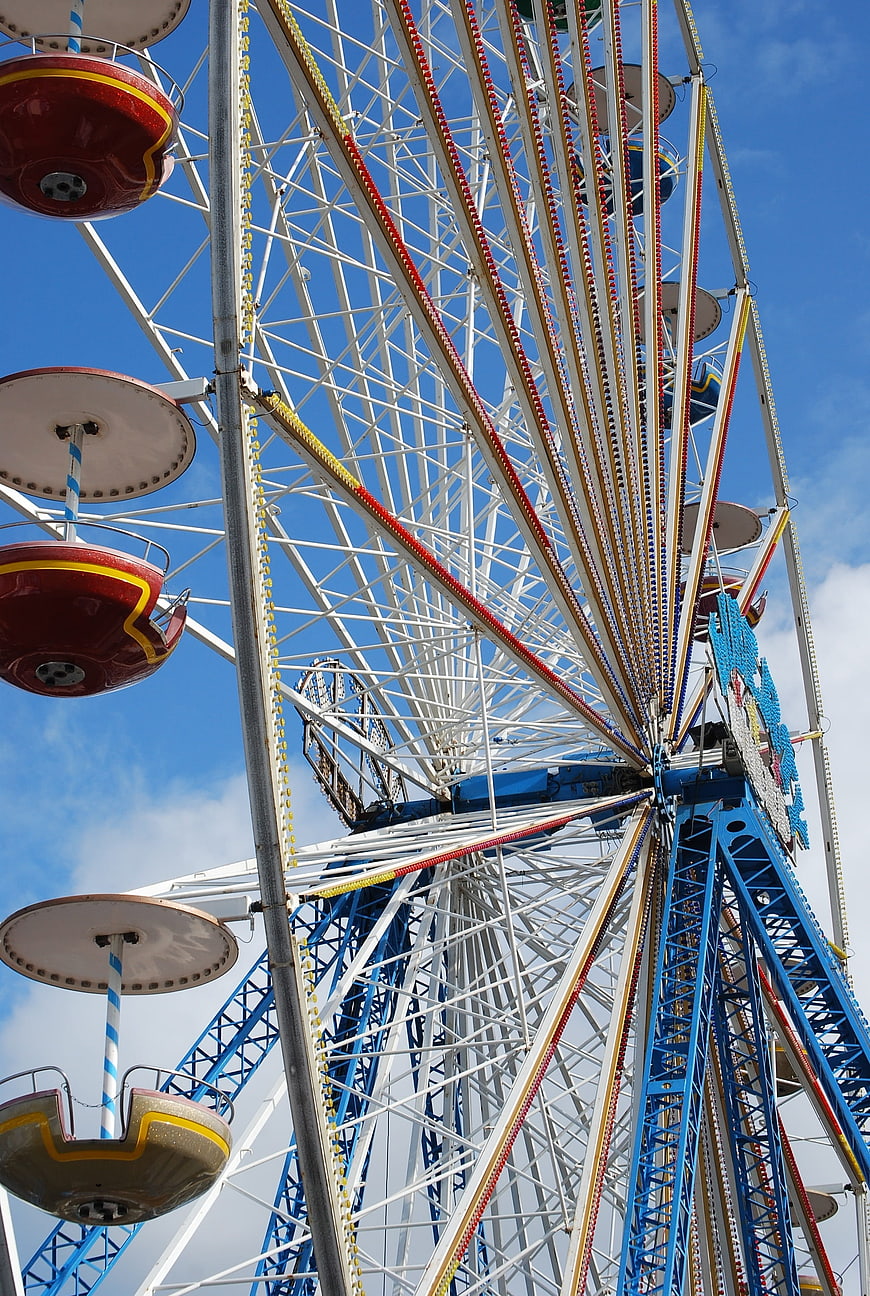 Low angle view of colorful ferris wheel against blue sky