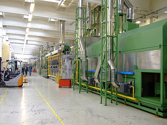 Industrial factory interior with green machinery and forklift