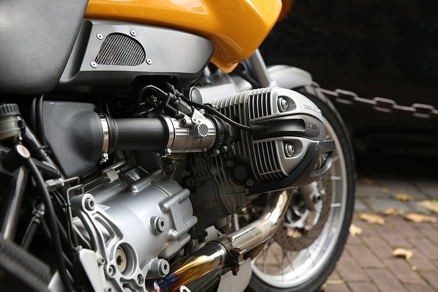 Close-up of yellow motorcycle engine and exhaust details