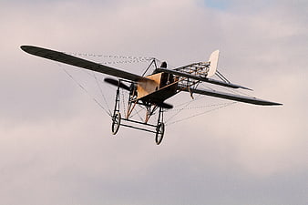 Vintage Biplane Flying Against Cloudy Sky