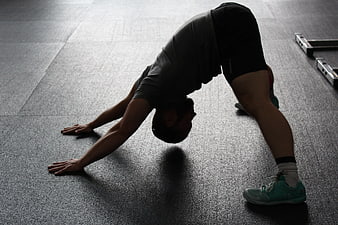 Man in Downward Dog Yoga Pose on Gym Floor