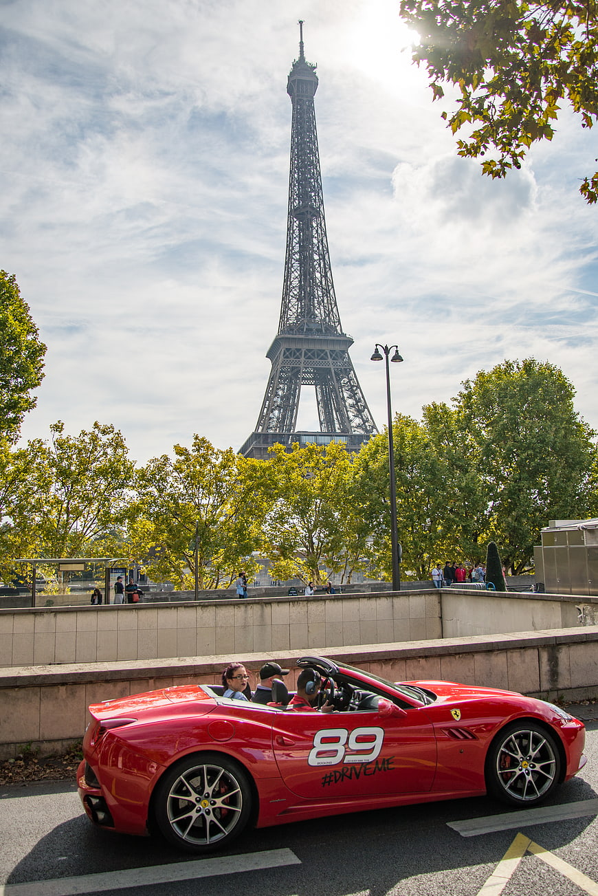Red Ferrari Convertible Driving Past Eiffel Tower in Paris