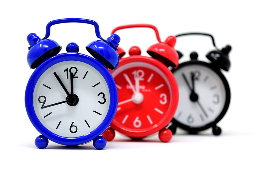 Colorful alarm clocks on white background
