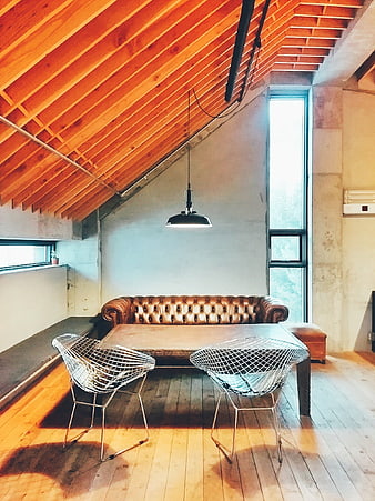Industrial Loft Interior With Brown Leather Chesterfield Sofa And Wire Chairs