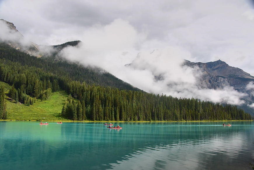 Red Canoes on Turquoise Mountain Lake with Misty Forest