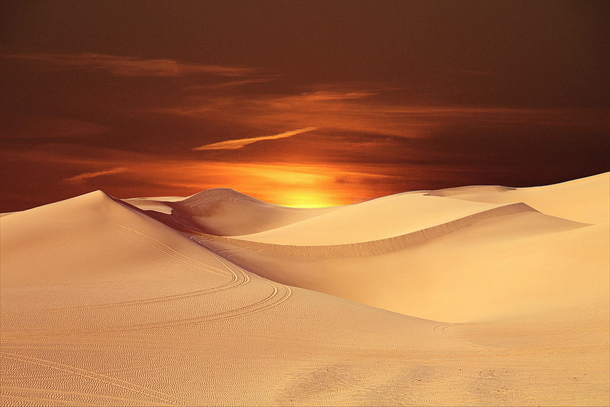 Golden Sunset Over Rolling Sand Dunes in Desert Landscape