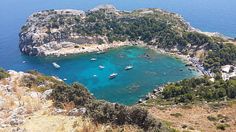 Aerial View of Turquoise Cove with Boats and Beach Umbrellas
