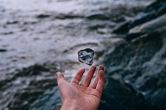 Hand Levitating Rock Over Ocean Waves