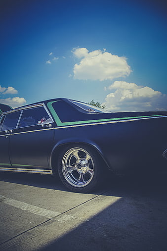 Low angle matte black classic car with chrome wheels