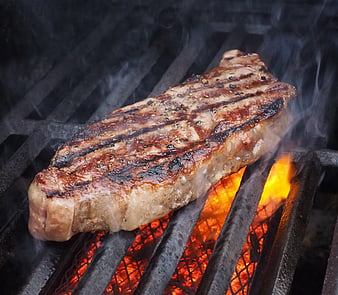 Juicy Grilled Steak Sizzling on Charcoal Grill with Flames