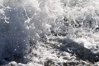 Close-up of crashing ocean waves with white sea foam texture