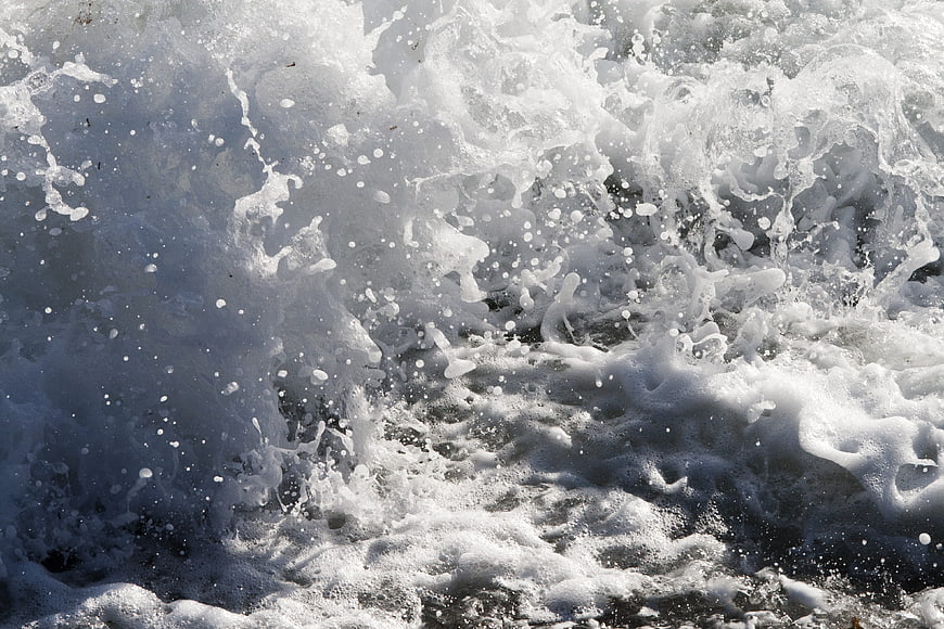 Close-up of crashing ocean waves with white sea foam texture