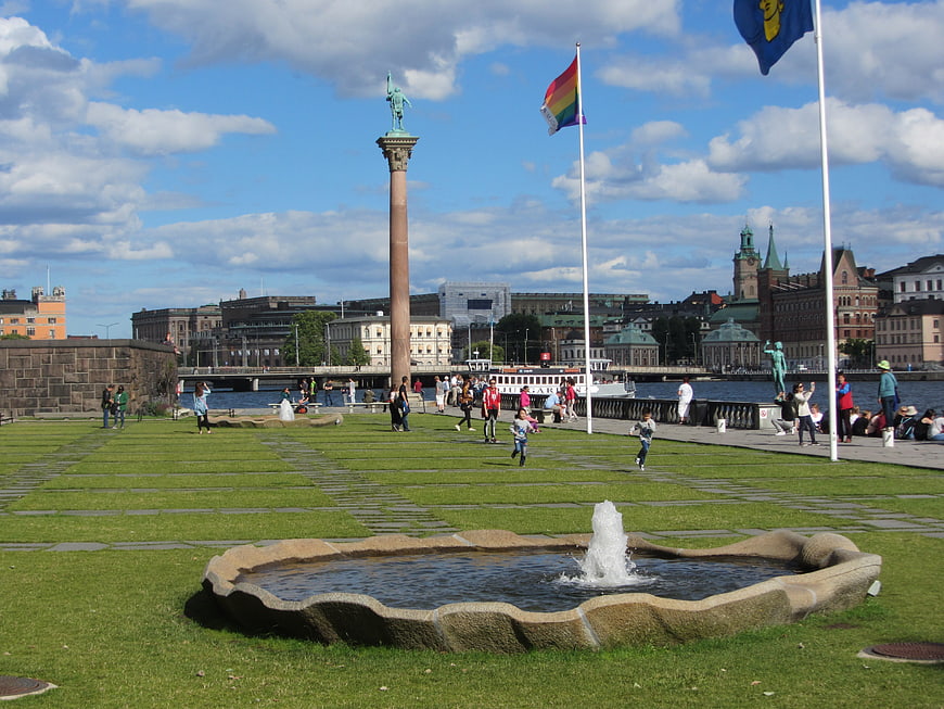 Stockholm Cityscape with Fountain, Statue, and Rainbow Flag