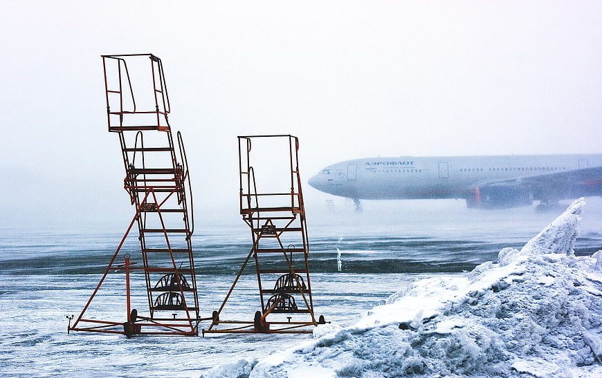 Aeroflot airplane landing on snowy runway with orange stairs