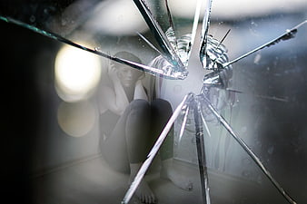Woman behind shattered glass representing anxiety and fear
