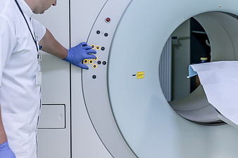 Doctor operating MRI machine control panel in hospital