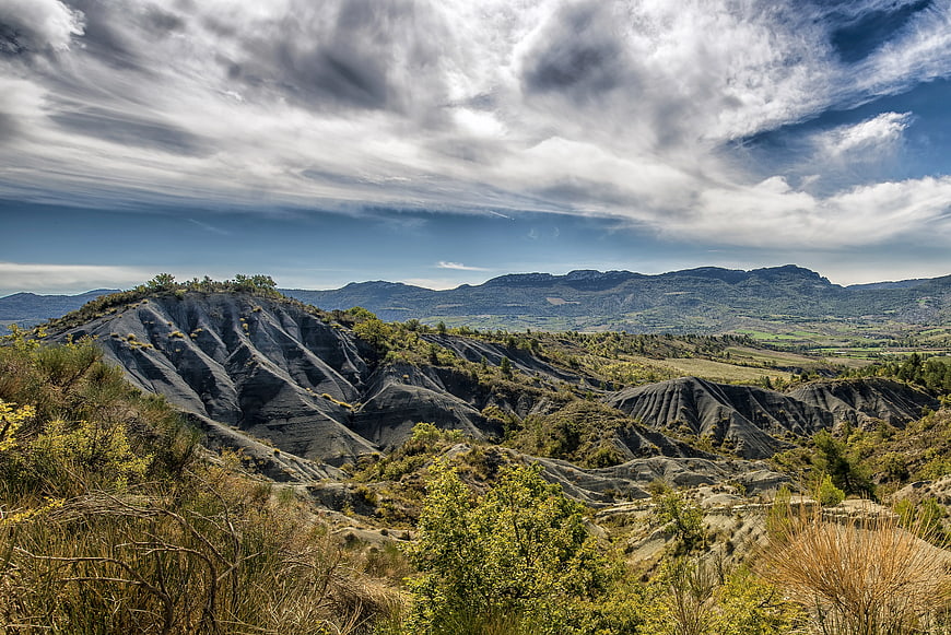 Dramatic Eroded Hills Landscape Under Cloudy Sky