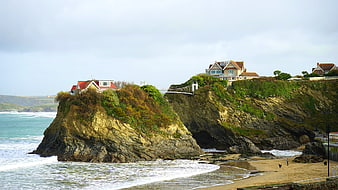 Cliffside houses with suspension bridge overlooking ocean beach