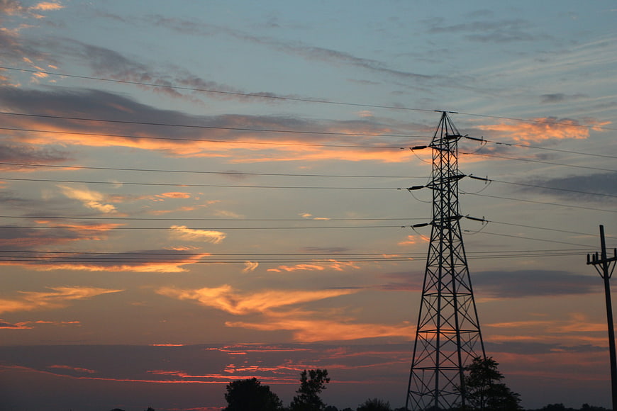 Silhouette of electricity pylon against colorful sunset sky