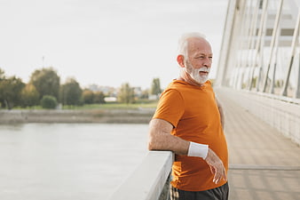 Senior man resting after running on bridge