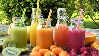 Colorful Fresh Fruit Juices in Glass Bottles with Straws
