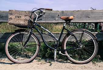 Vintage black bicycle with wooden crate on sandy beach