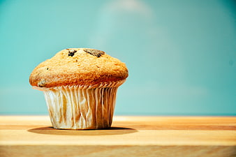 Chocolate Chip Muffin on Wooden Table with Teal Background