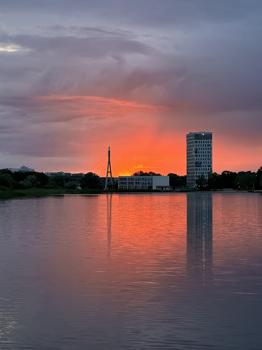 Vibrant Sunset Reflection on River with City Skyline
