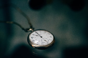 Vintage pocket watch hanging on a chain close up