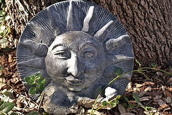 Stone Sun Face Sculpture in Garden