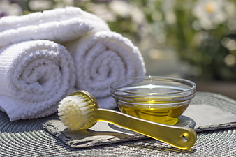 Spa towels, massage oil, and brush on slate