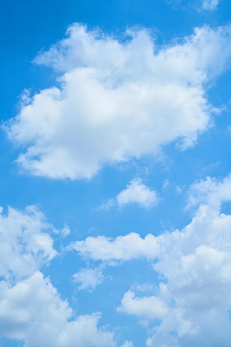 Fluffy white clouds against a bright blue sky background